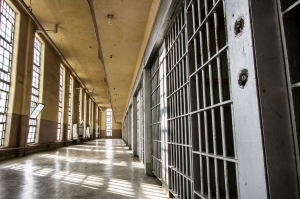 A bright and empty corridor in a prison facility.