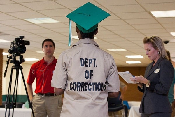 A student is interviewed by a local TV station after graduating from high school in prison.