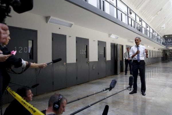 Barack Obama standing in the El Reno Federal Correctional Institution and being interviewed by the press.