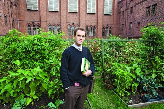 Portrait of Max Kenner standing in a garden.