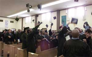 BPI students stand and toss their caps into the air after a commencement ceremony.