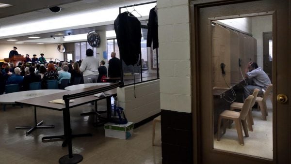 An incarcerated person watches graduation from the visitation bays at the Missouri Eastern Correctional Center