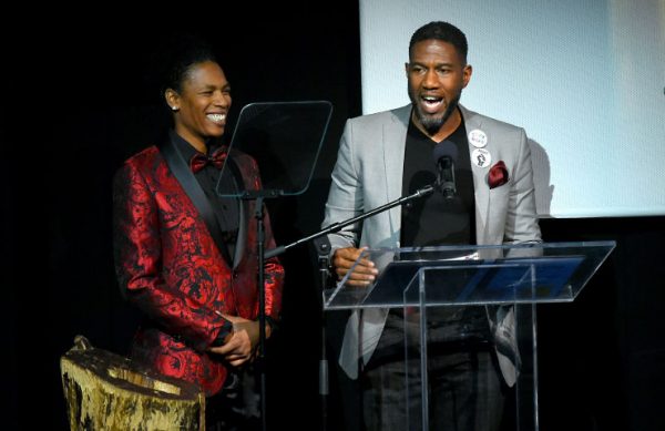 Tamika Graham smiling and standing next to Jumaane Williams as he speaks on stage.