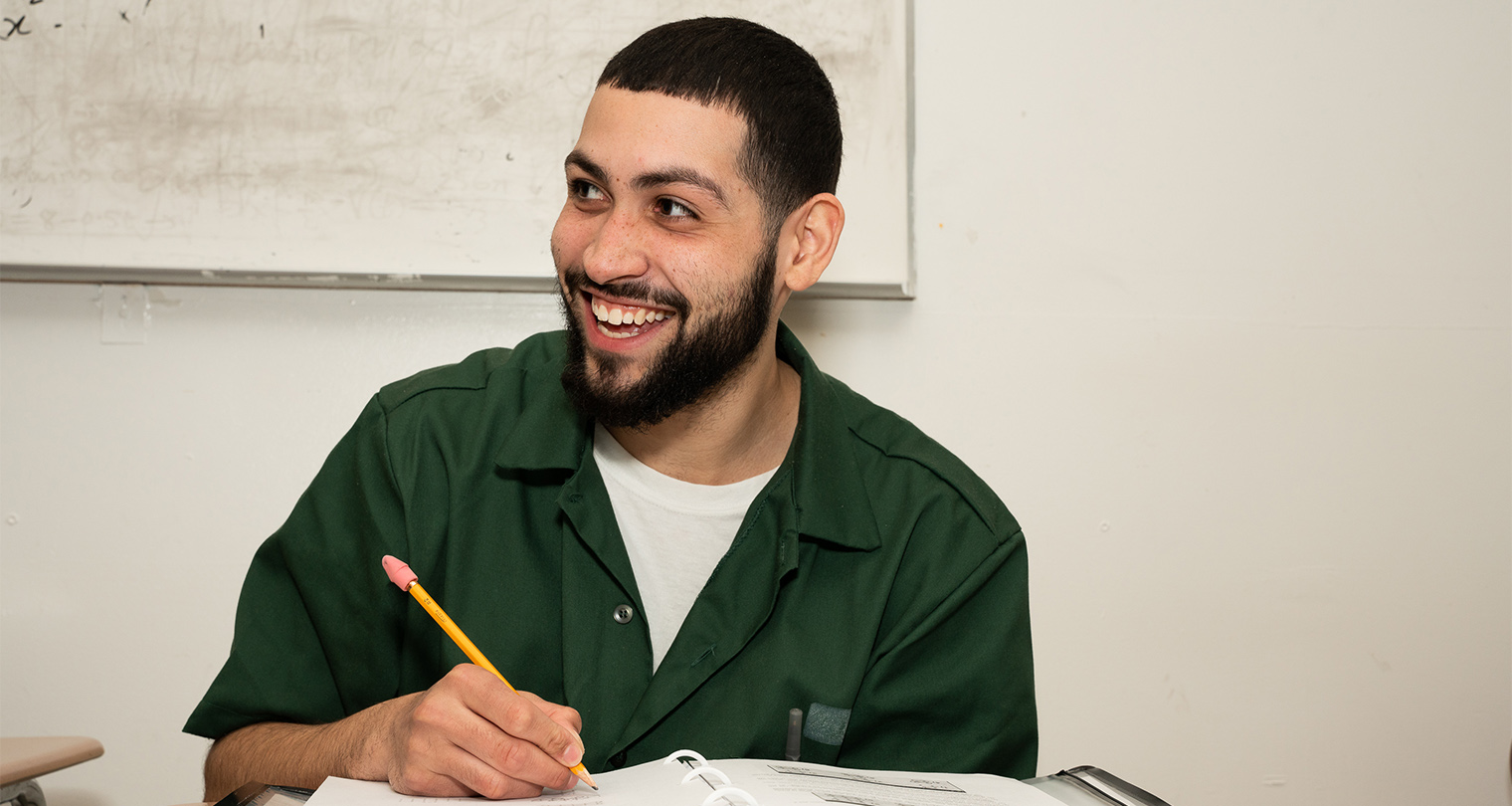 BPI student smiling while working. Work towards you Bard Prison Initiative Degree.