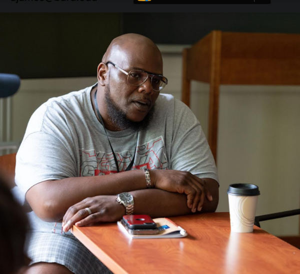 Demetrius James sitting at a desk in a classroom 