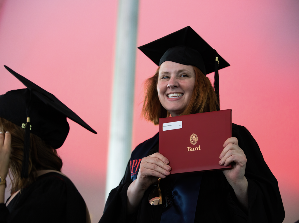 Graduate Stacy Burnett holding up her Bard diploma