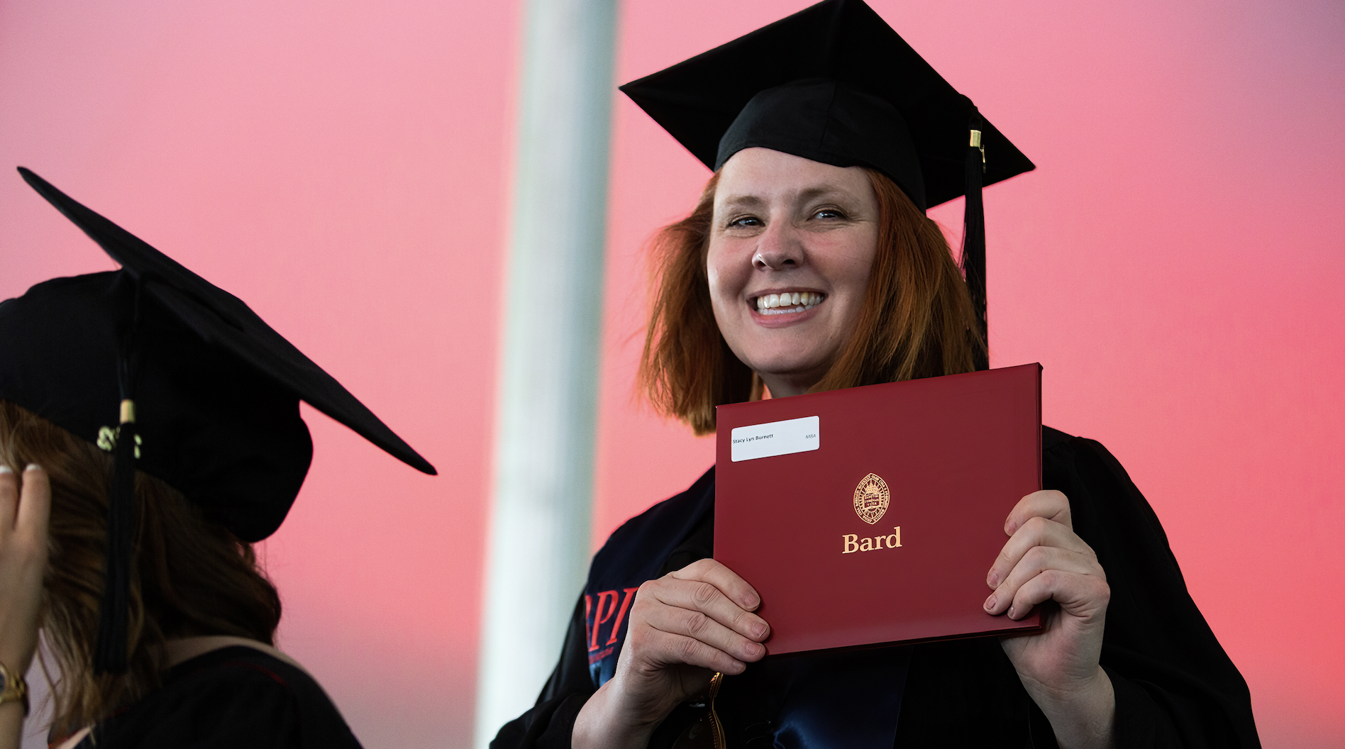 Graduate Stacy Burnett holding up her Bard diploma