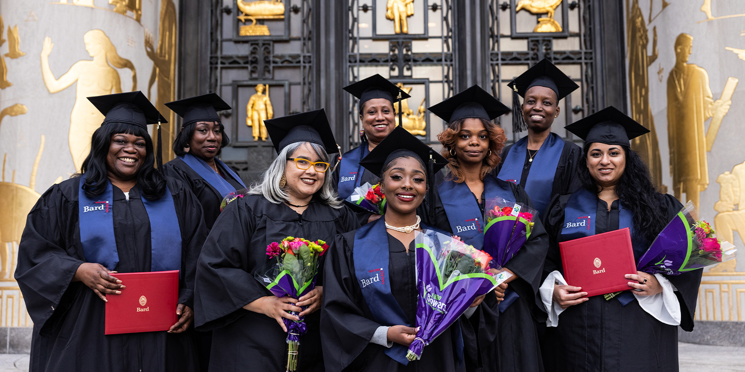 Microcollege students pose on the steps of the Brooklyn Central Library in graduation robes.