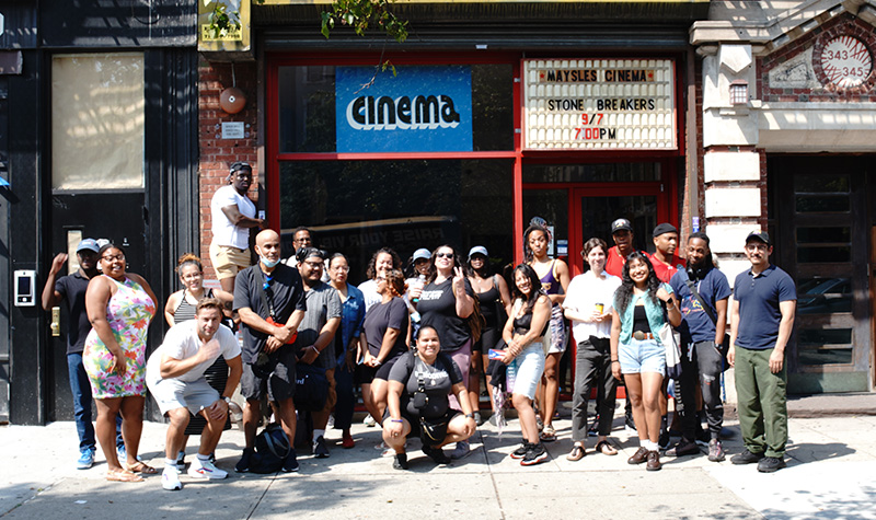 Harlem students posing in front of a cinema storefront.