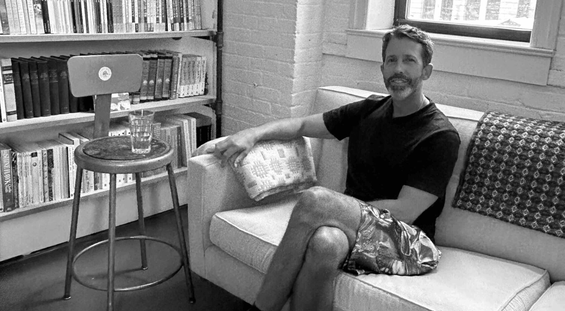 Black and white image of author Javier Fuentes in the offices of The Paris Review