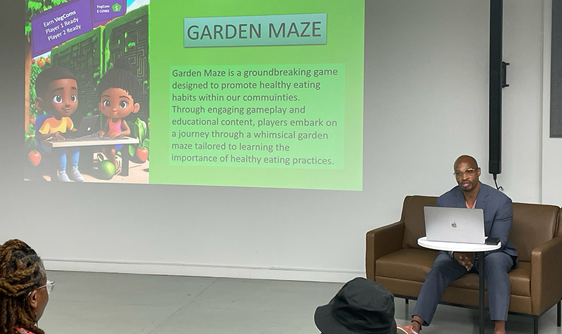 Student sits in front of a projection screen giving a presentation