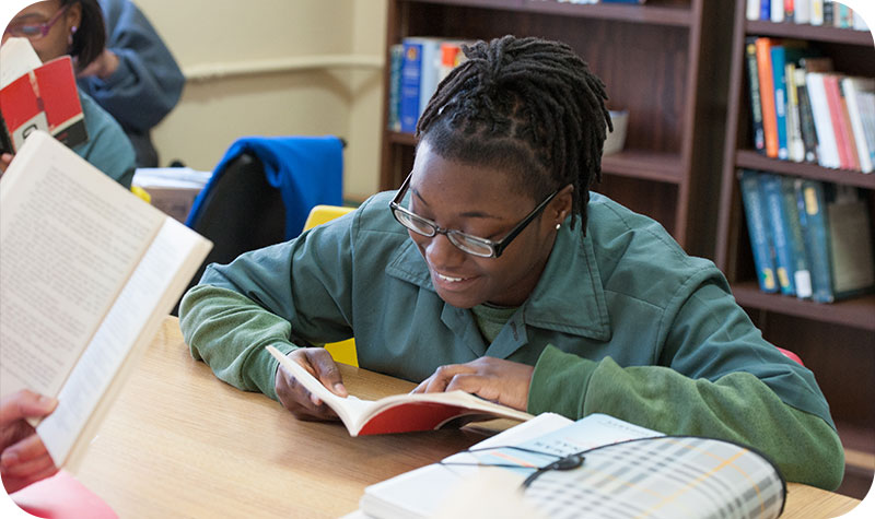 A student smiles while reading a book.